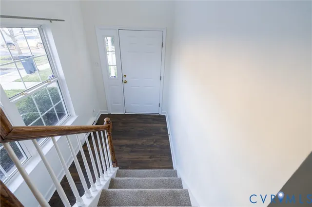 a view of a hallway with wooden floor and staircase