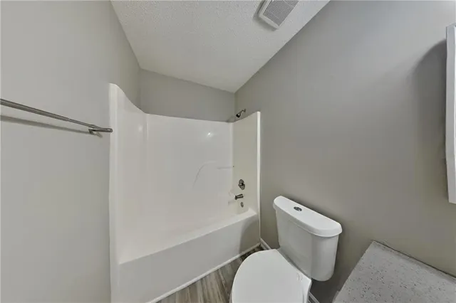 a white toilet sitting next to a bath tub