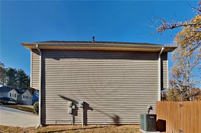 a view of a house with a small yard and wooden fence