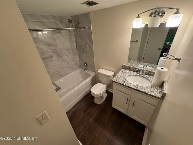 a view of a hallway with wooden floor and door