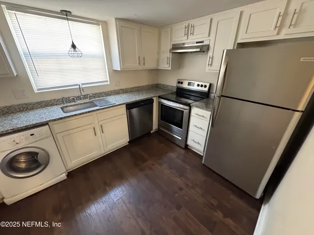 a kitchen with a sink a stove a refrigerator and cabinets