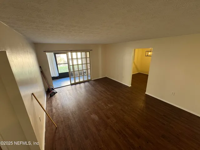a view of an empty room with wooden floor