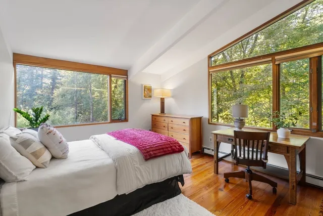 a bedroom with a bed and a large window