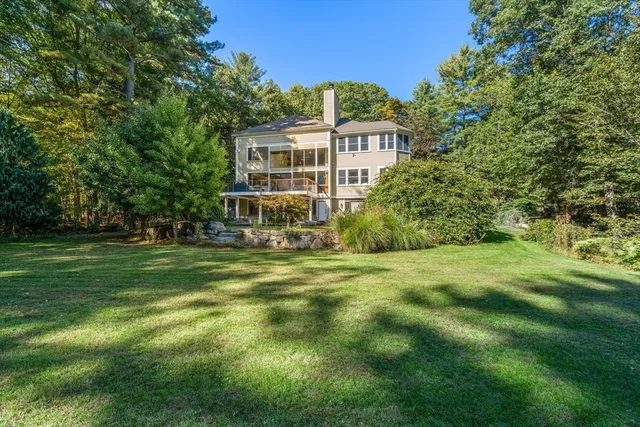 a view of a house with a big yard and large trees