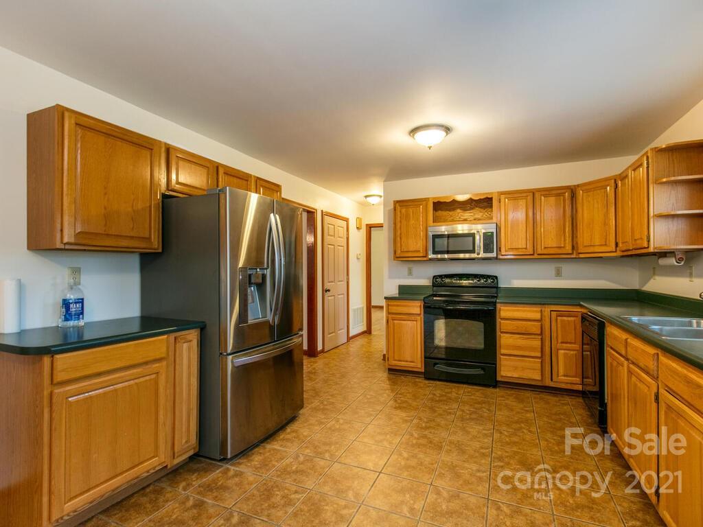 20 Brooks Branch Road Leicester, NC 28748 - Photo 17 of 40 a kitchen with stainless steel appliances granite countertop a stove a sink dishwasher a refrigerator and cabinets with wooden floor