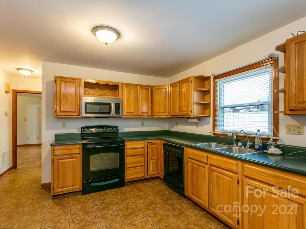 20 Brooks Branch Road Leicester, NC 28748 - Photo 18 of 40 a kitchen with stainless steel appliances granite countertop a stove a sink and a microwave