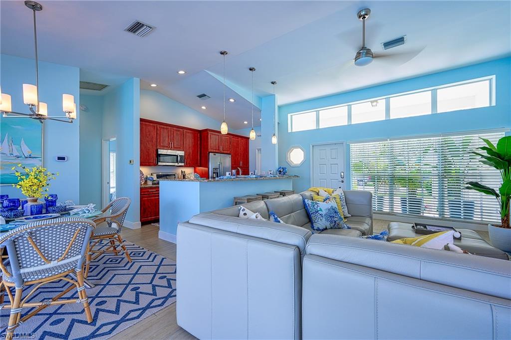 7311 Mill Pond Circle Naples, FL 34109 - Photo 14 of 42 a kitchen with a refrigerator and a dining table