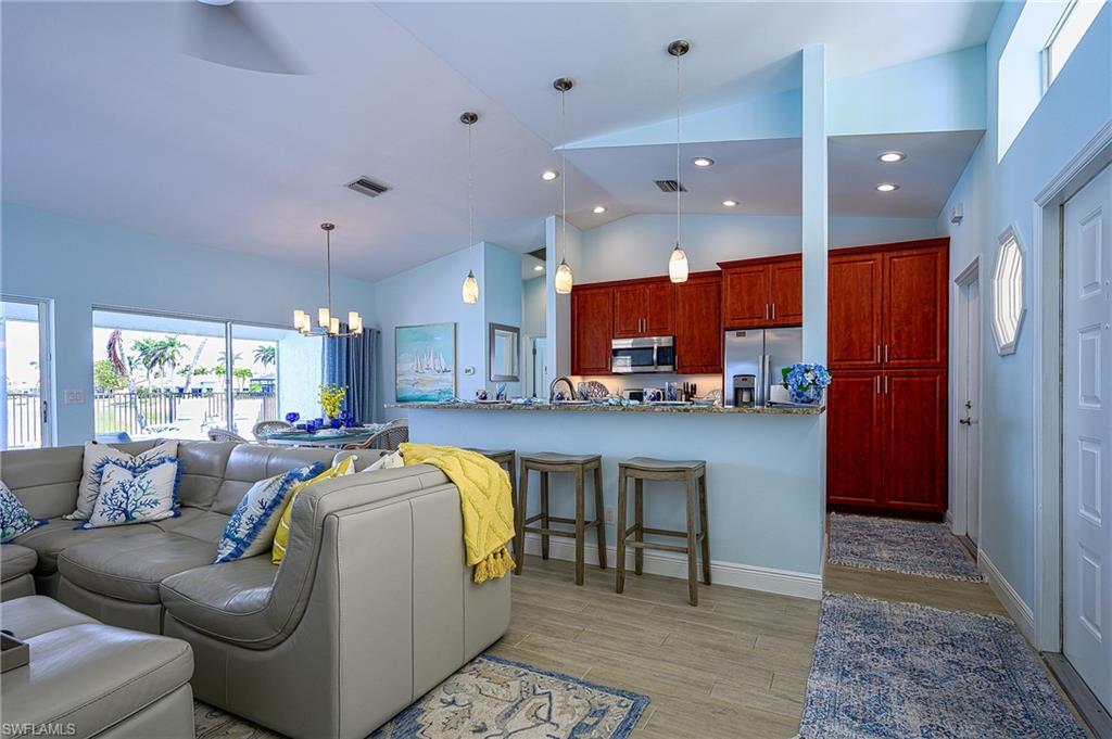 7311 Mill Pond Circle Naples, FL 34109 - Photo 18 of 42 a living room with furniture and a dining table with kitchen view