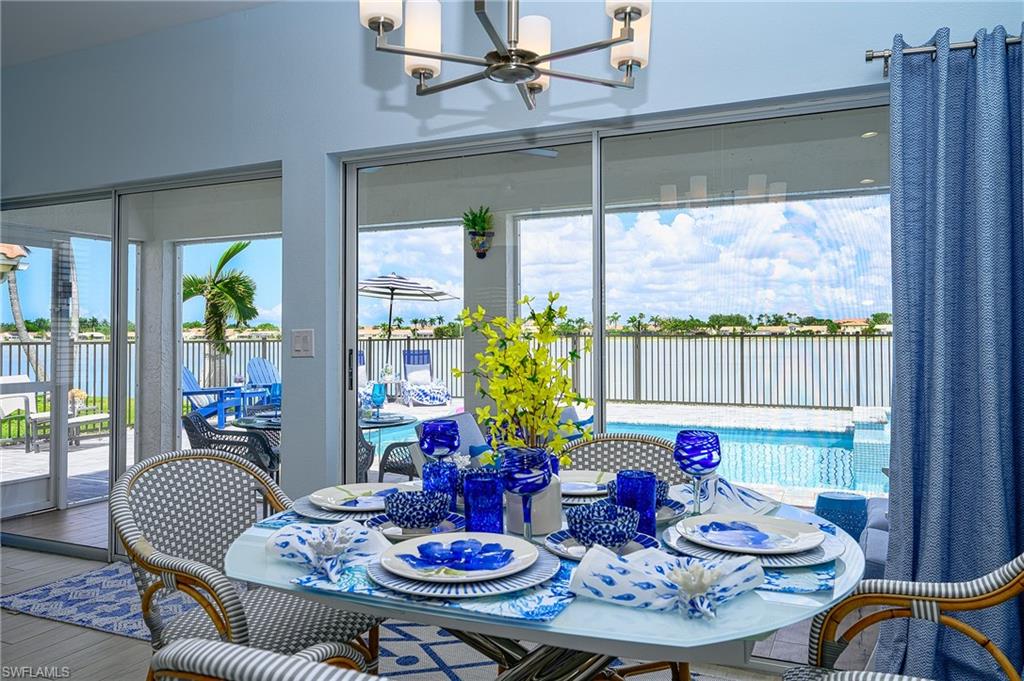 7311 Mill Pond Circle Naples, FL 34109 - Photo 19 of 42 a outdoor dining room with furniture large windows and wooden floor