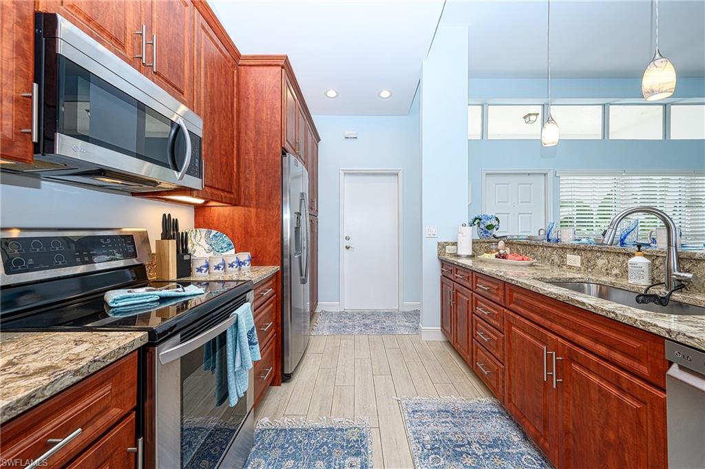 7311 Mill Pond Circle Naples, FL 34109 - Photo 20 of 42 a kitchen with stainless steel appliances granite countertop a stove and a sink