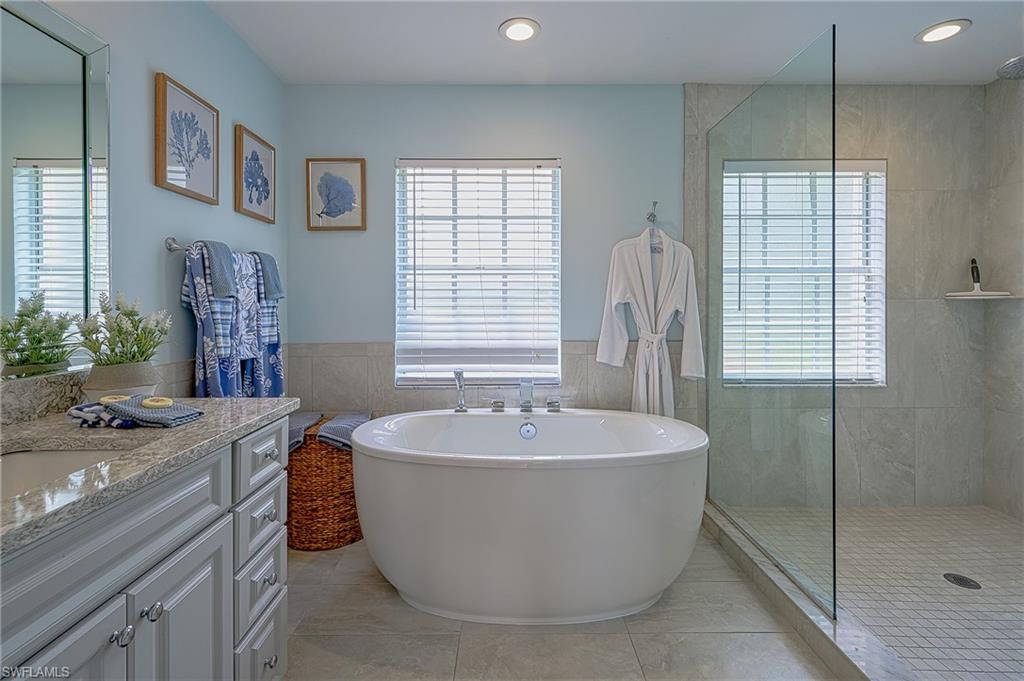 7311 Mill Pond Circle Naples, FL 34109 - Photo 24 of 42 a spacious bathroom with sink a mirror a bathtub and shower