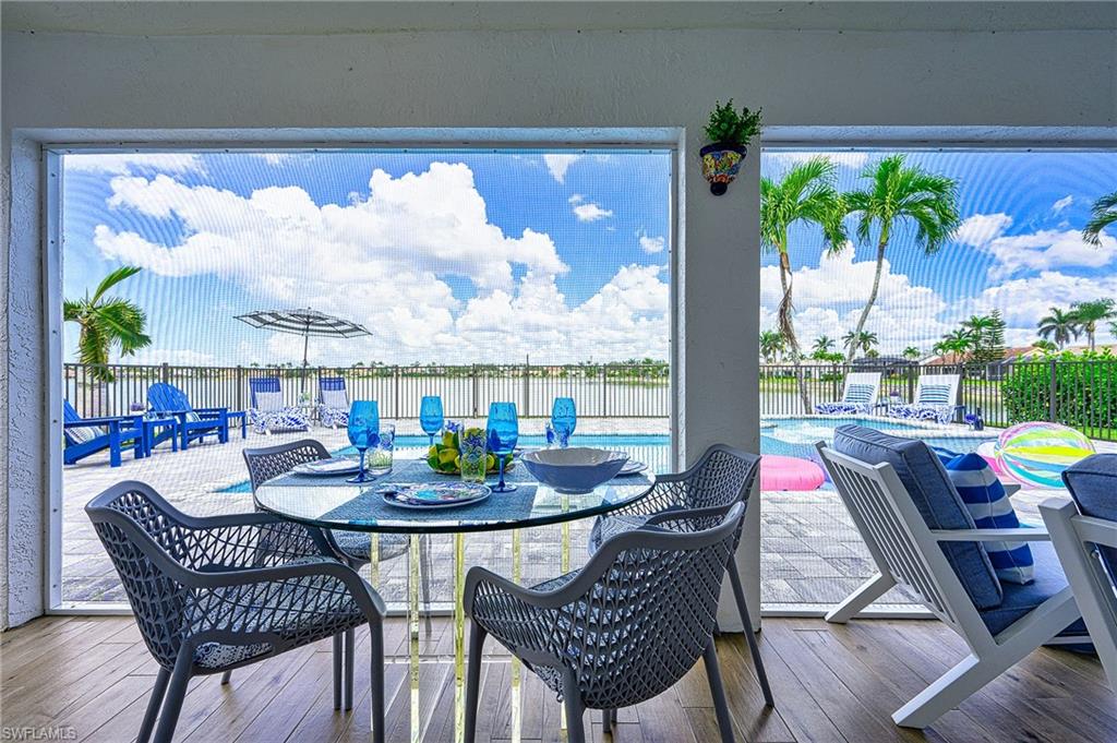 7311 Mill Pond Circle Naples, FL 34109 - Photo 31 of 42 a dining room with furniture a rug and a floor to ceiling window