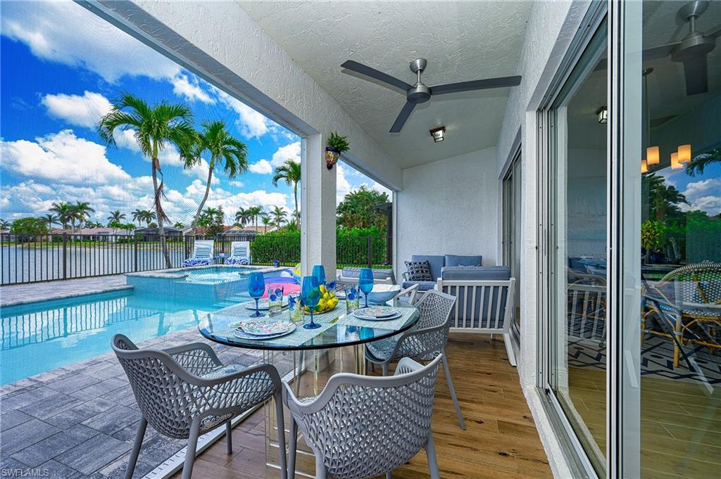 7311 Mill Pond Circle Naples, FL 34109 - Photo 33 of 42 a view of a patio with a dining table and chairs with wooden floor