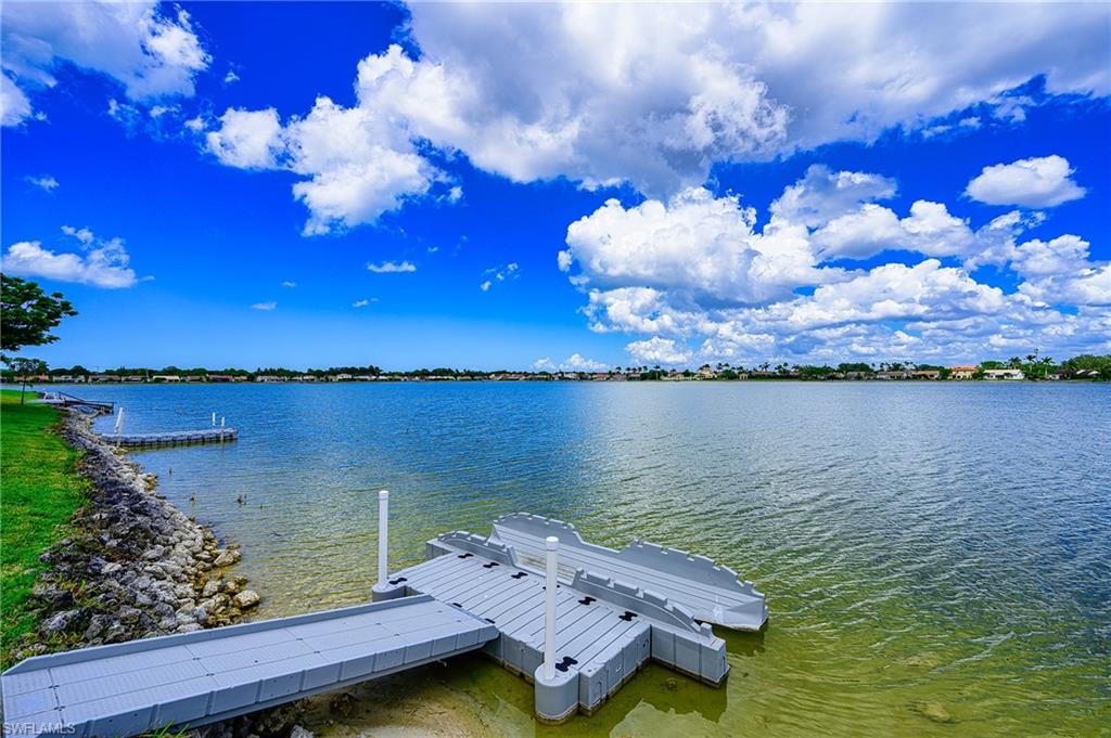 7311 Mill Pond Circle Naples, FL 34109 - Photo 36 of 42 a view of a lake with lawn chairs