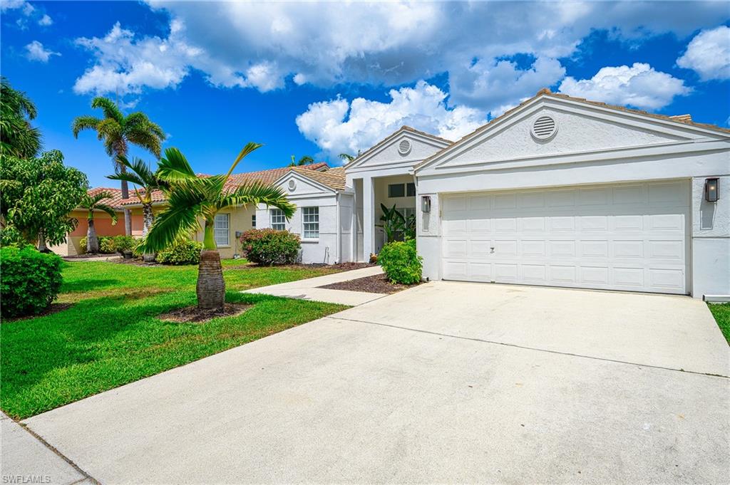 7311 Mill Pond Circle Naples, FL 34109 - Photo 40 of 42 a view of a white house with a large tree and plants