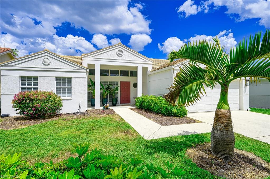 7311 Mill Pond Circle Naples, FL 34109 - Photo 42 of 42 a front view of a house with a garden