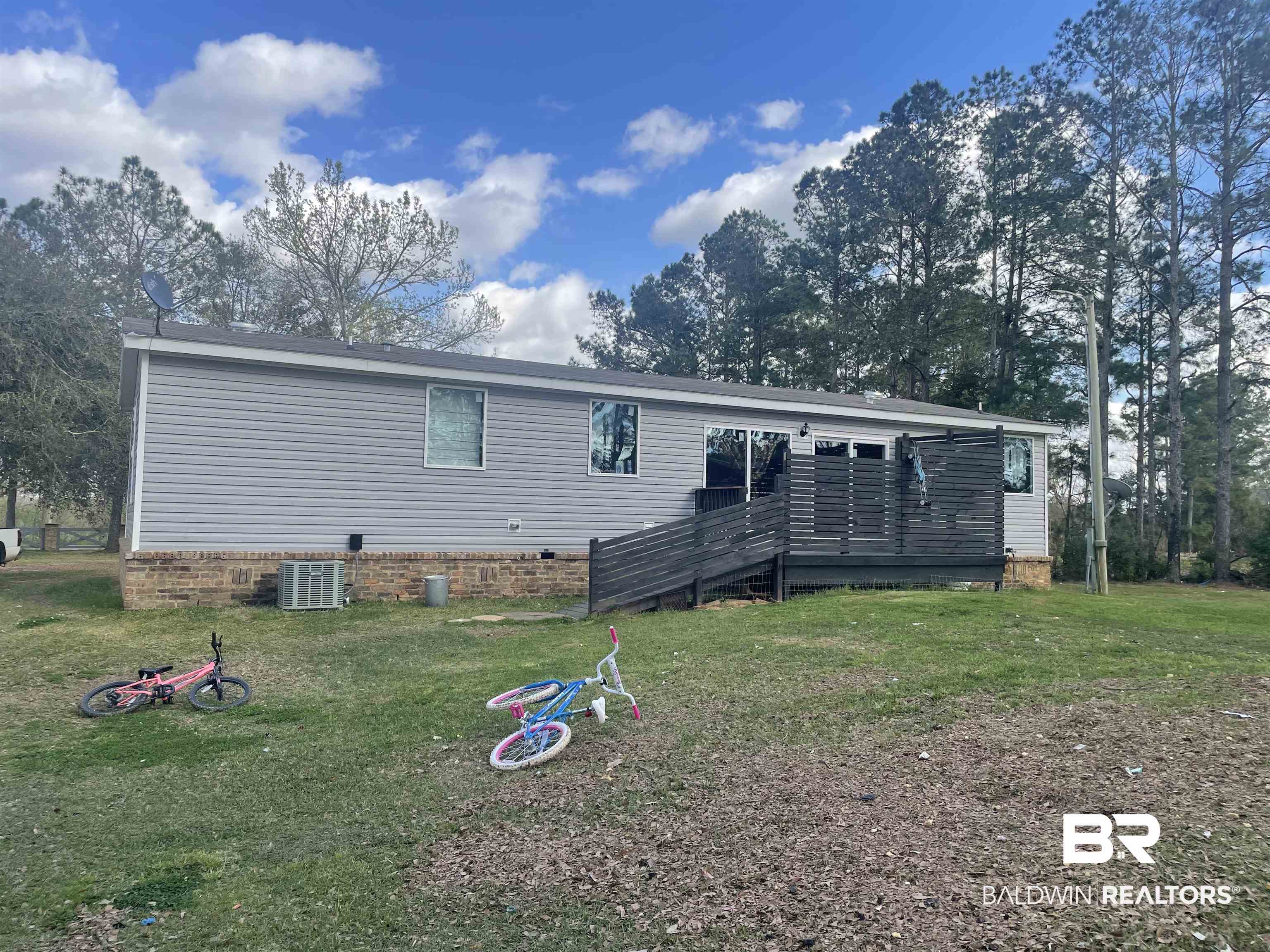 21593 Hubbard Road Robertsdale, AL 36567 - Photo 3 of 22 Rear view of house featuring crawl space, a lawn, and central AC unit