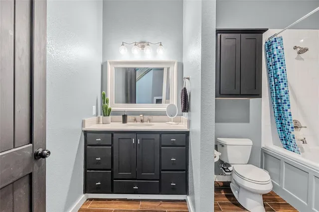 a bathroom with a granite countertop toilet sink and mirror