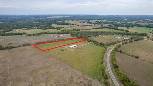 an aerial view of a residential houses with outdoor space and river