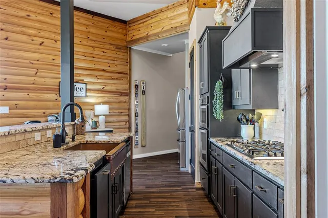 a kitchen with stainless steel appliances granite countertop a sink and a stove