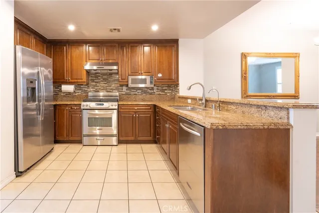 a kitchen with stainless steel appliances granite countertop a sink stove and refrigerator