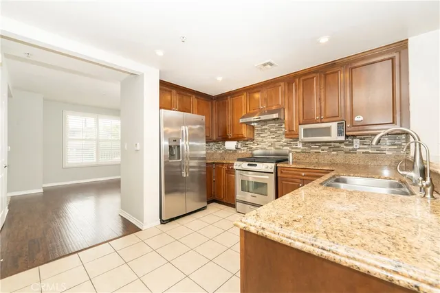 a kitchen with granite countertop a sink stainless steel appliances and counter space