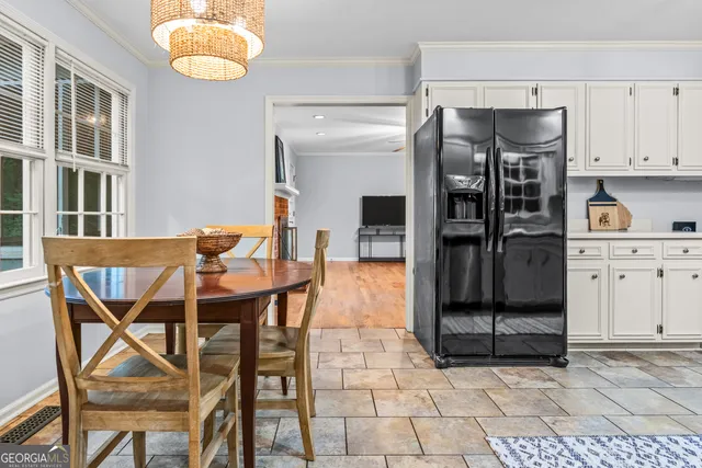 a kitchen with stainless steel appliances a dining table and chairs