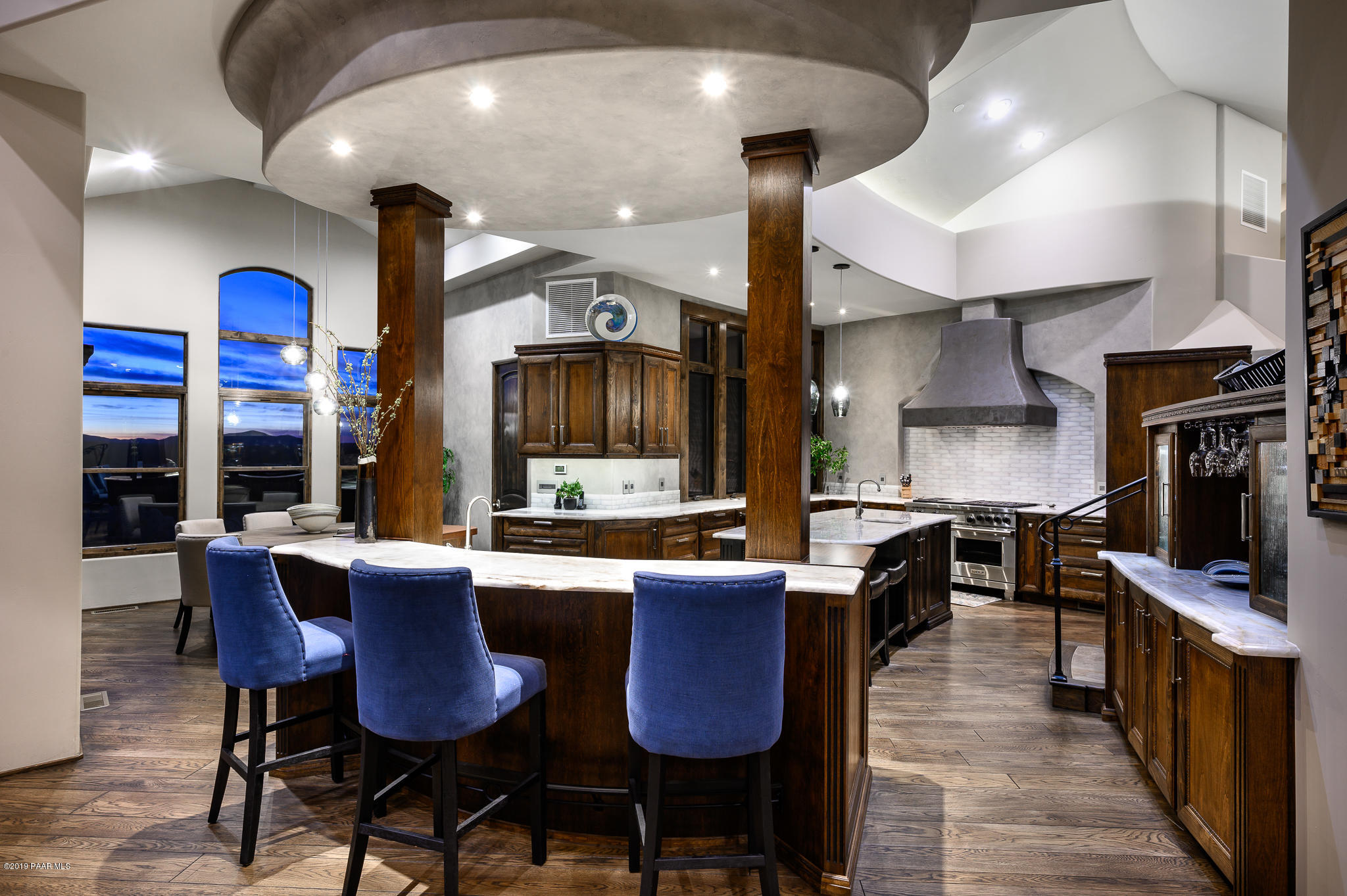 6785 West Almosta Ranch Road Prescott, AZ 86305 - Photo 18 of 81 a kitchen with stainless steel appliances kitchen island granite countertop a dining table chairs sink and wooden cabinets