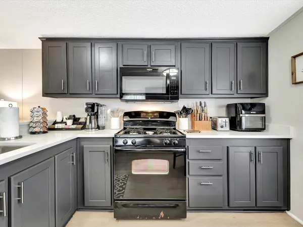 a kitchen with a table chairs microwave and cabinets