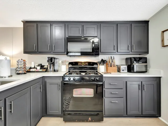 a kitchen with a table chairs microwave and cabinets