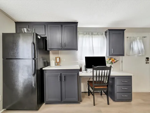 a kitchen with a refrigerator and cabinets