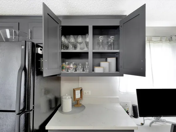 a kitchen with a refrigerator a stove a sink a dining table and chairs