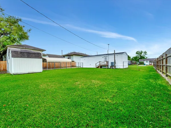 a view of a house with a big yard and a large tree