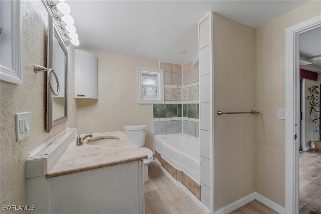 10925 Russell Road Bokeelia, FL 33922 - Photo 40 of 50 a bathroom with a granite countertop sink toilet and shower