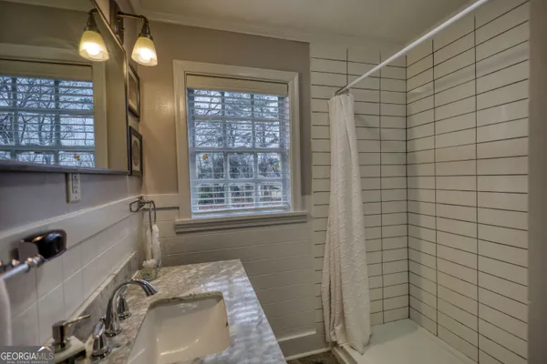 an empty room with wooden floor cabinet and windows