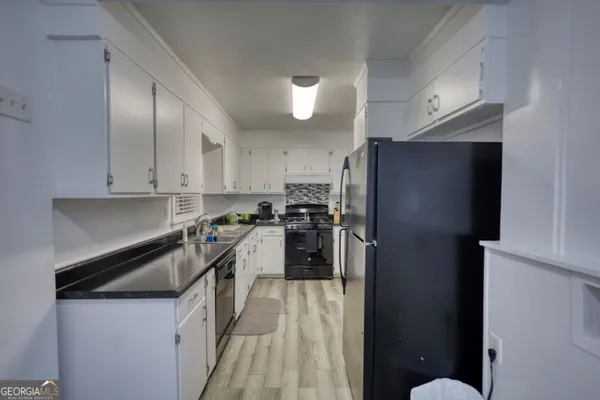 a kitchen with granite countertop stainless steel appliances a refrigerator a stove top oven a sink and dishwasher