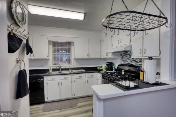 a view of a kitchen with a stove cabinets and a wooden floor