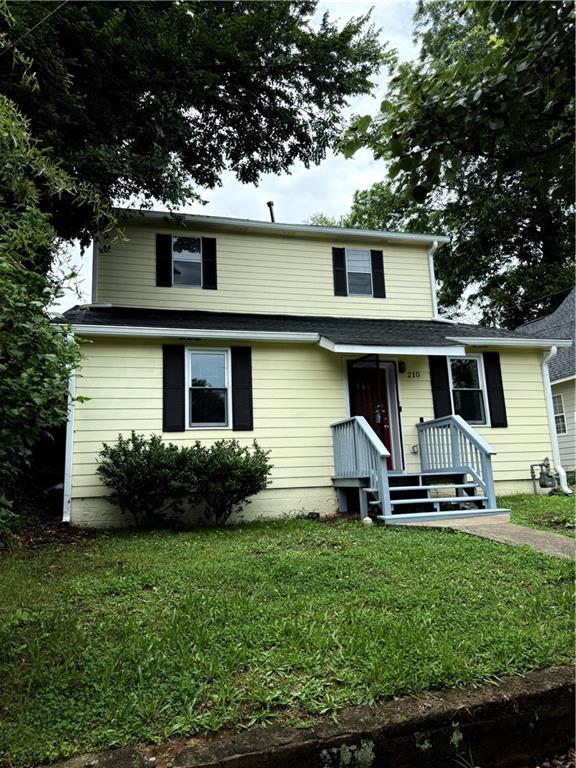 a front view of a house with a yard and green space