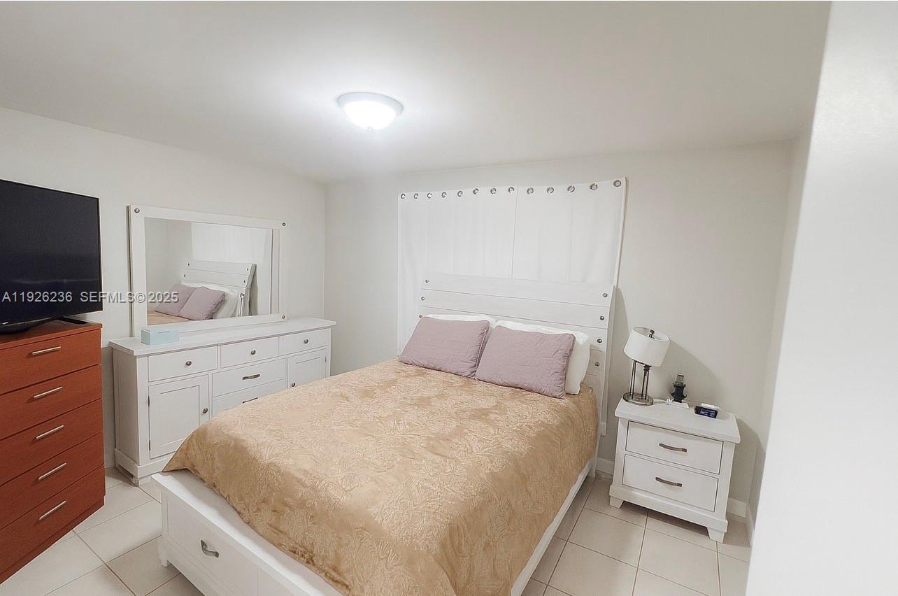 2275 Southwest 15th Street Miami, FL 33145 - Photo 7 of 10 a bedroom with a large bed and a flat tv screen on the dresser