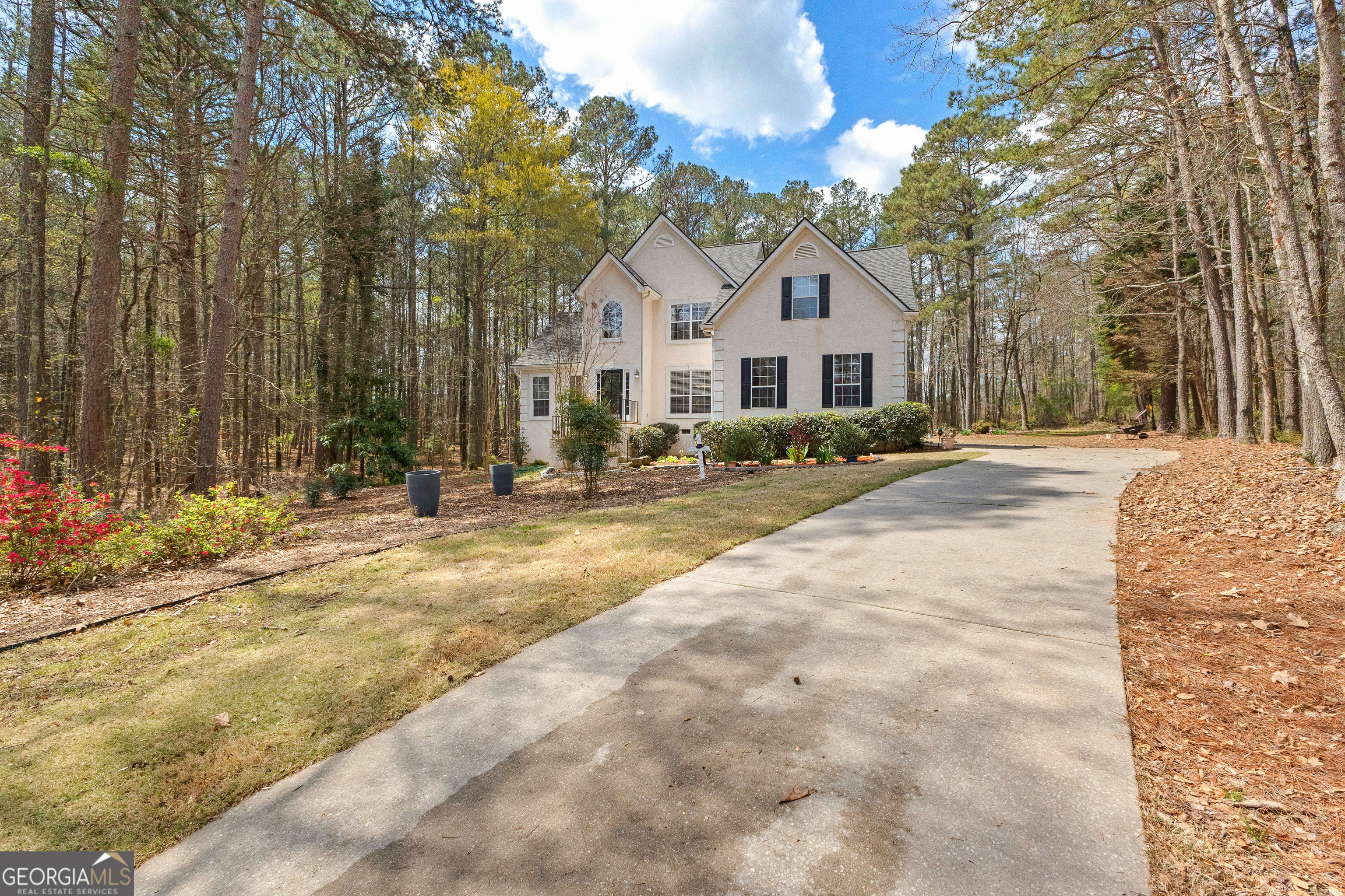 a view of a white house with a big yard and large trees