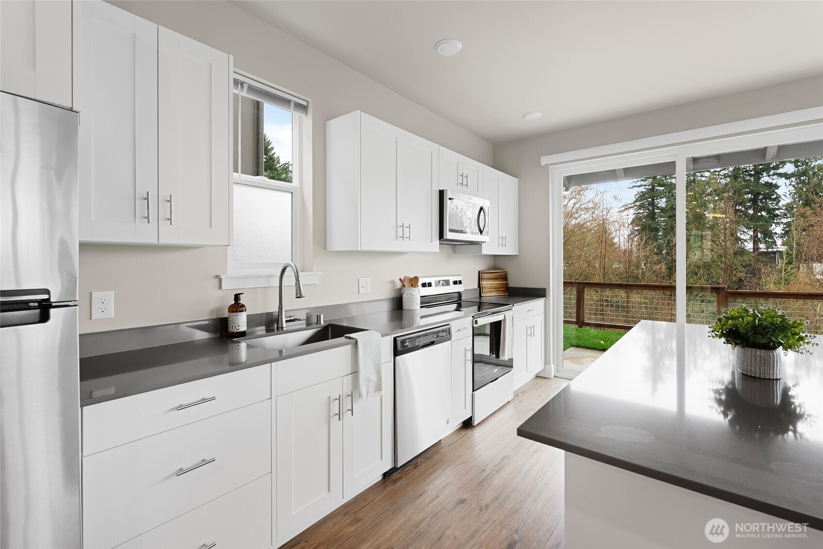 1884 Front Street, Unit B Lynden, WA 98264 - Photo 6 of 14 a kitchen with granite countertop a sink a counter top space cabinets and stainless steel appliances