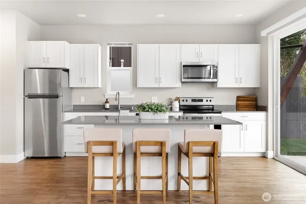 a kitchen with stainless steel appliances granite countertop a refrigerator and a stove top oven