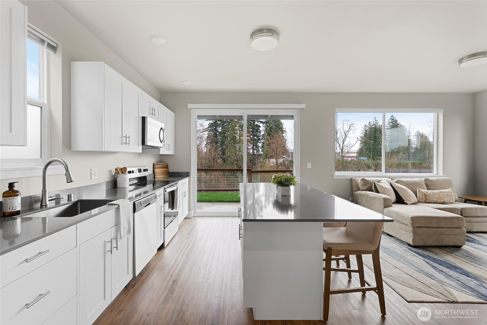 1884 Front Street, Unit B Lynden, WA 98264 - Photo 10 of 14 a large kitchen with kitchen island a large window cabinets a sink and stainless steel appliances