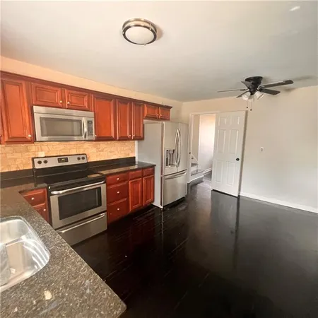 a kitchen with stainless steel appliances granite countertop a stove a sink and a refrigerator