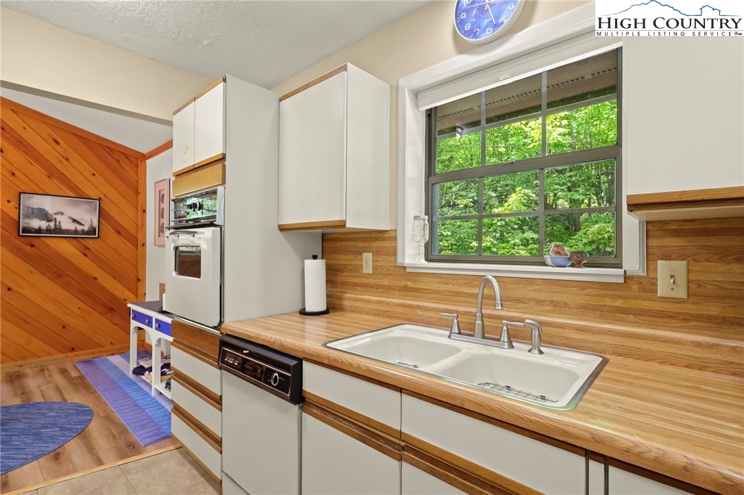 311 Pine Ridge Road Beech Mountain, NC 28604 - Photo 15 of 37 a kitchen with stainless steel appliances granite countertop a sink and a wooden cabinets