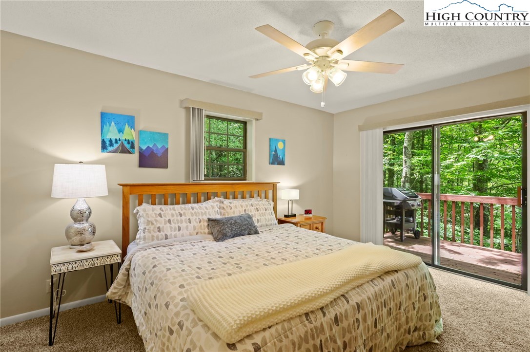 311 Pine Ridge Road Beech Mountain, NC 28604 - Photo 17 of 37 a bedroom with a large bed and a chandelier