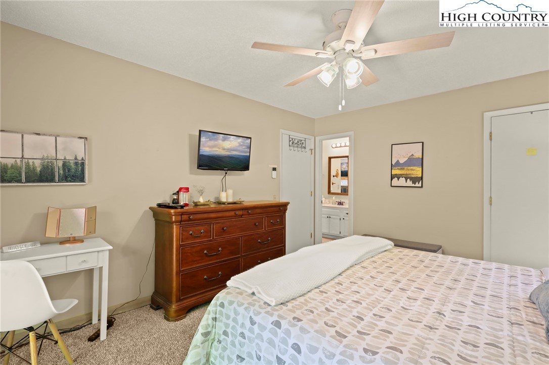 311 Pine Ridge Road Beech Mountain, NC 28604 - Photo 18 of 37 a bedroom with a bed and a chandelier