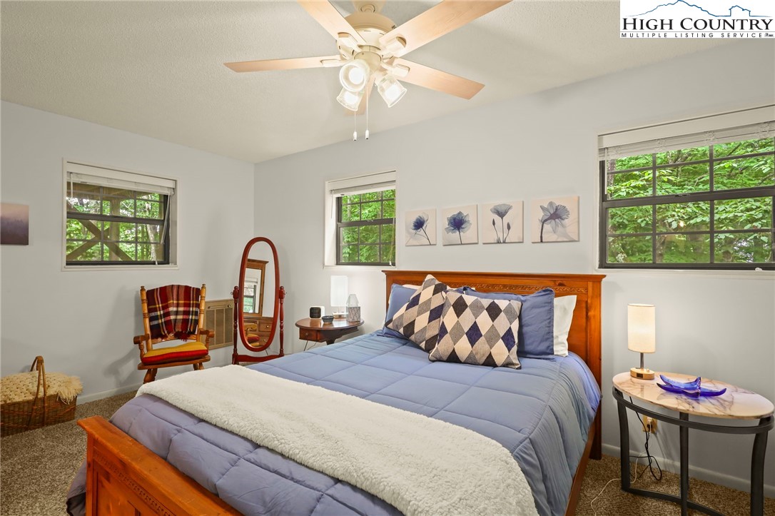311 Pine Ridge Road Beech Mountain, NC 28604 - Photo 21 of 37 a bedroom with a bed and a chandelier