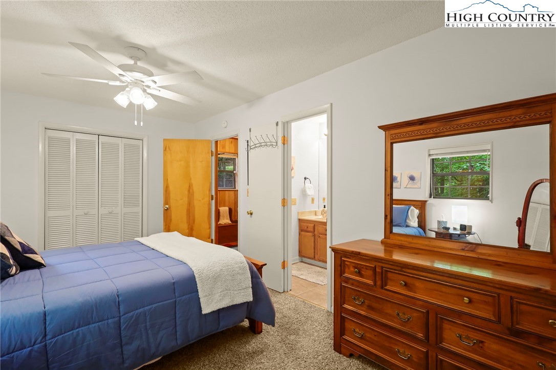 311 Pine Ridge Road Beech Mountain, NC 28604 - Photo 22 of 37 a bedroom with a bed and a chandelier