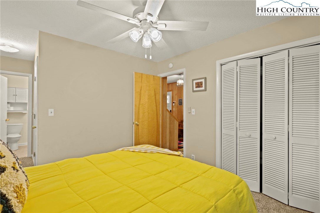 311 Pine Ridge Road Beech Mountain, NC 28604 - Photo 27 of 37 a bedroom with a bed and a chandelier